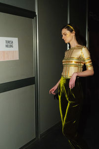 Close-up of woman standing against wall