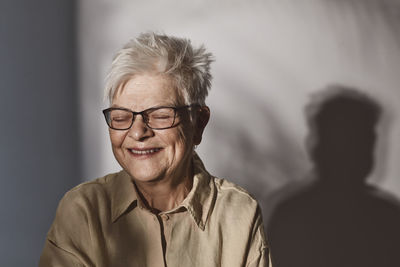 Happy senior woman with eyeglasses over white background