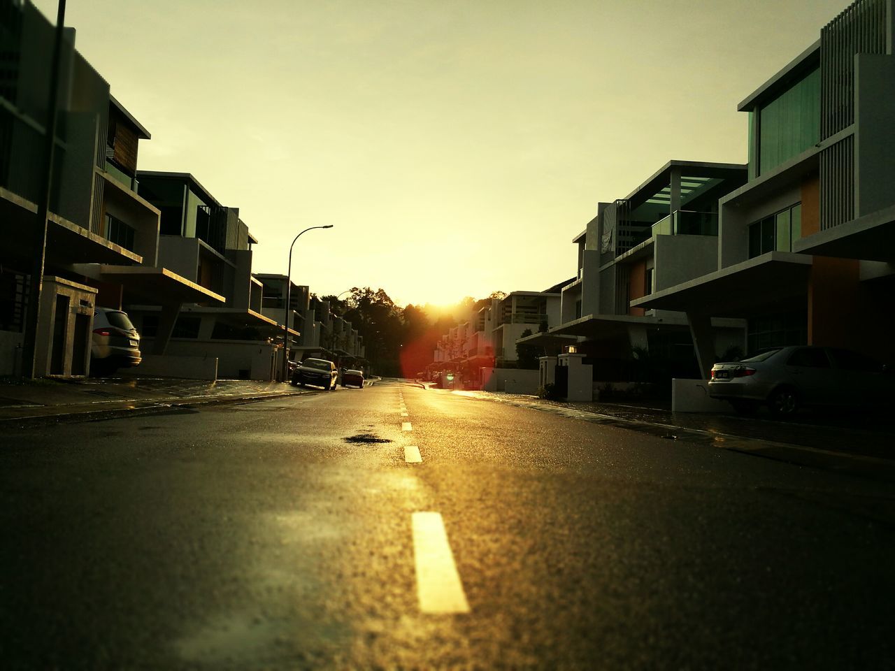 WET ROAD AGAINST SKY DURING SUNSET