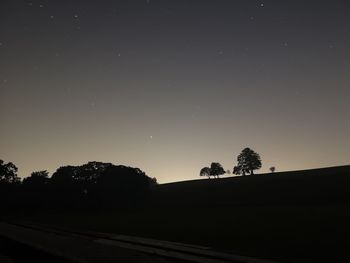 Silhouette trees against sky at night