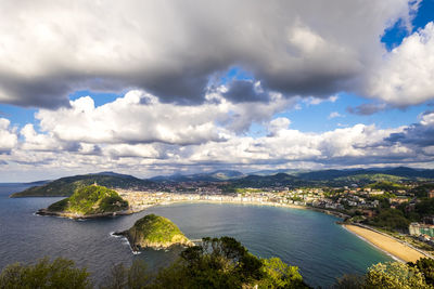 Aerial view of city by sea against sky