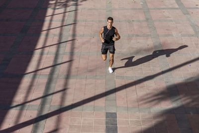 High angle view of man running on footpath