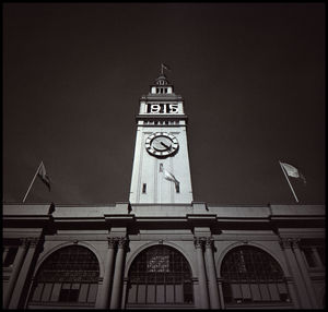 Low angle view of clock tower against sky at night