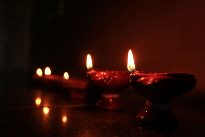 Close-up of lit diya in darkroom