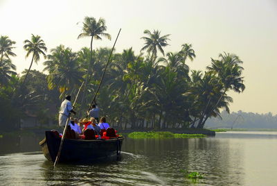 Rear view of people in boat on river