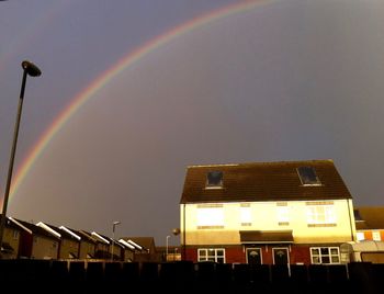 Low angle view of rainbow over buildings