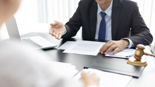 Midsection of business colleagues working at desk in office