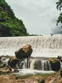 Scenic view of waterfall against sky