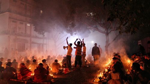 People are praying and dancing in a religious event caled rakher upobash