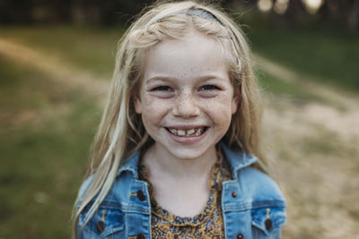 Close up portrait of school aged girl smiling outside