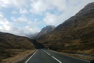 Road amidst mountains against sky