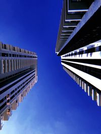 Low angle view of modern buildings against clear blue sky