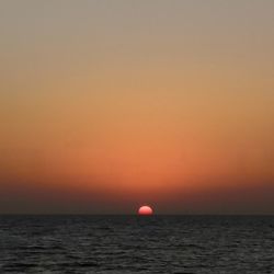 Scenic view of sea against orange sky