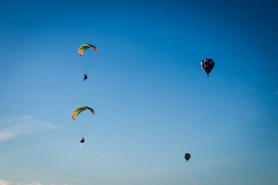 Low angle view of paragliding against clear sky