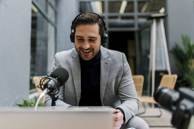 Businessman talking on microphone while sitting at cafe