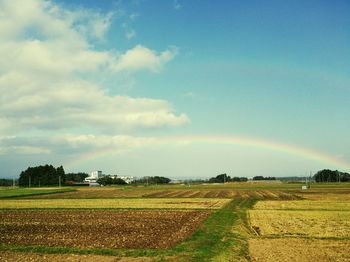 Scenic shot of rainbow over countryside landscape