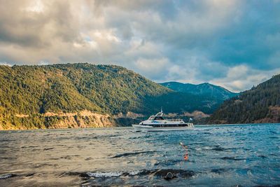 Scenic view of sea and mountains against sky