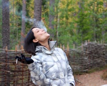Woman emitting smoke while looking up