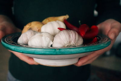 Midsection of person holding ingredients in bowl at home