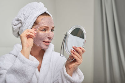 Close-up of young woman with facial mask