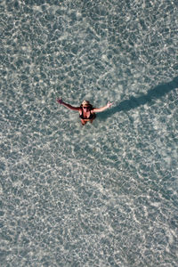 Attractive woman greetings from water. aerial view.