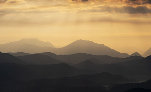 Scenic view of silhouette mountains against sky at sunset