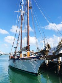 Sailboat moored at harbor against sky