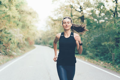 Portrait of young woman standing on road
