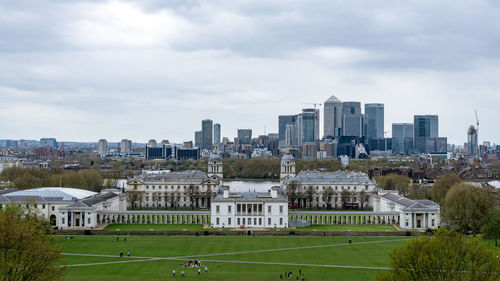 Buildings in city against cloudy sky