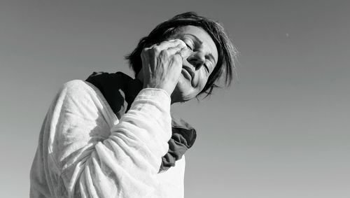 Low angle view of woman standing against sky