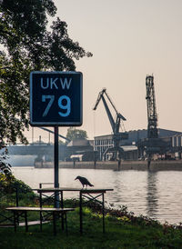 Information sign by sea against clear sky