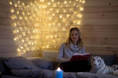 Young beautiful girl reading a book on the couch.