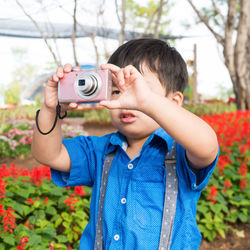 Portrait of boy photographing with camera