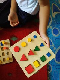 Midsection of woman holding multi colored wooden toys at home