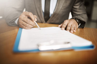 Midsection of businessman working on table