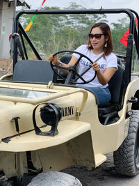 Rear view of women sitting on jeep, pull bear models