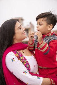 Mother and son embracing while standing outdoors