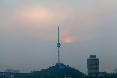 Communications tower against cloudy sky