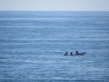 People in sea against sky