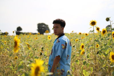 Young man standing in a sunflower field
