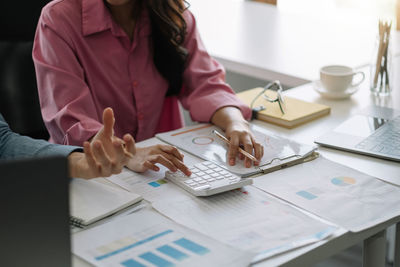 Midsection of business colleagues working at desk in office