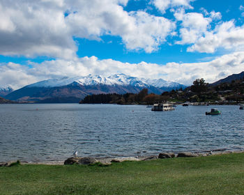 Scenic view of lake by mountains against sky