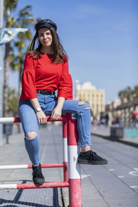 Smiling teenage girl wearing red top in city during sunny day