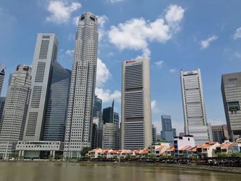 Low angle view of skyscrapers against cloudy sky