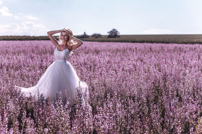 Full length of woman standing on field against sky