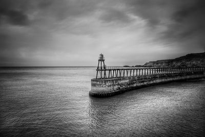 Scenic view of lighthouse by sea against sky