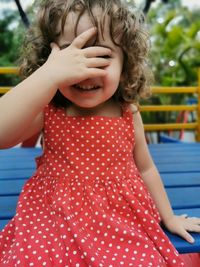 Little girl playing covering her face with her hand