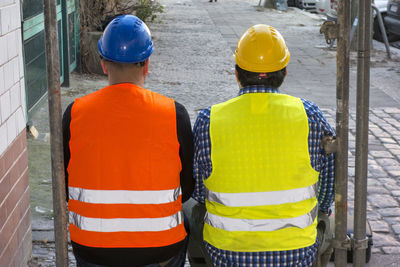 Rear view of men working with umbrella