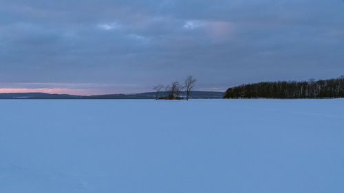 Scenic view of snow covered field against sky