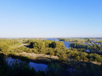 Scenic view of lake against clear blue sky